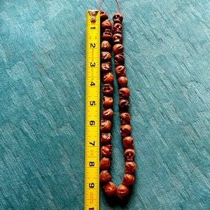 Strand of unique hand carved wooden skull beads